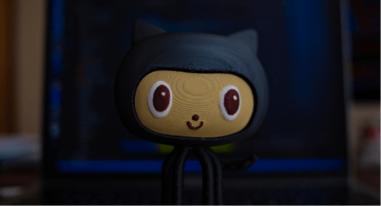 small cute wooden figure with big eyes smiling in a black cat suit